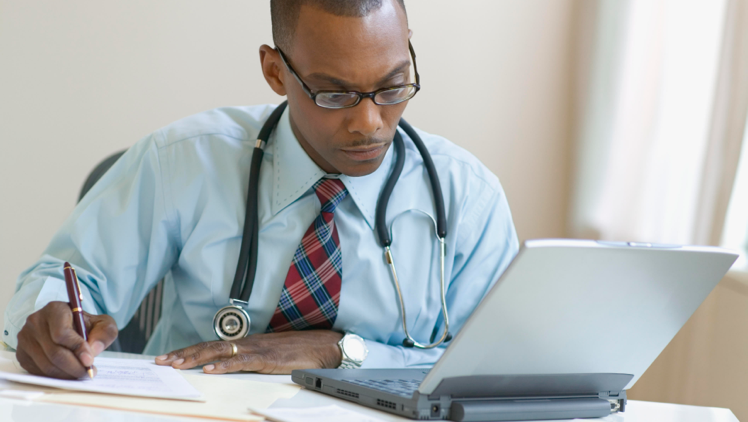 Image of a healthcare professional working on a laptop