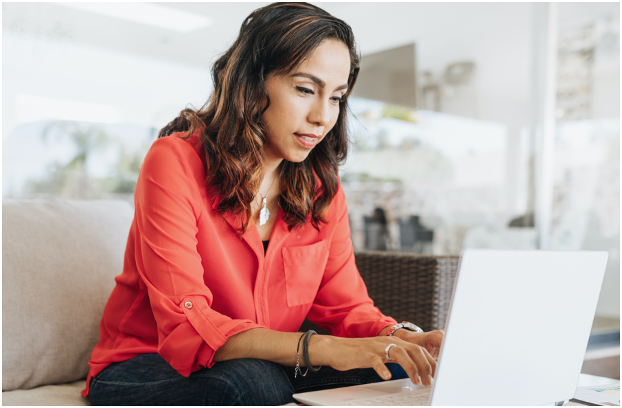 Image of a woman sitting and working on a laptop