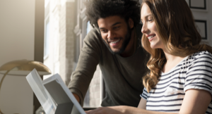 Image of a happy couple look at a laptop screen