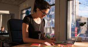 Image of a woman sitting at a desk working on a laptop
